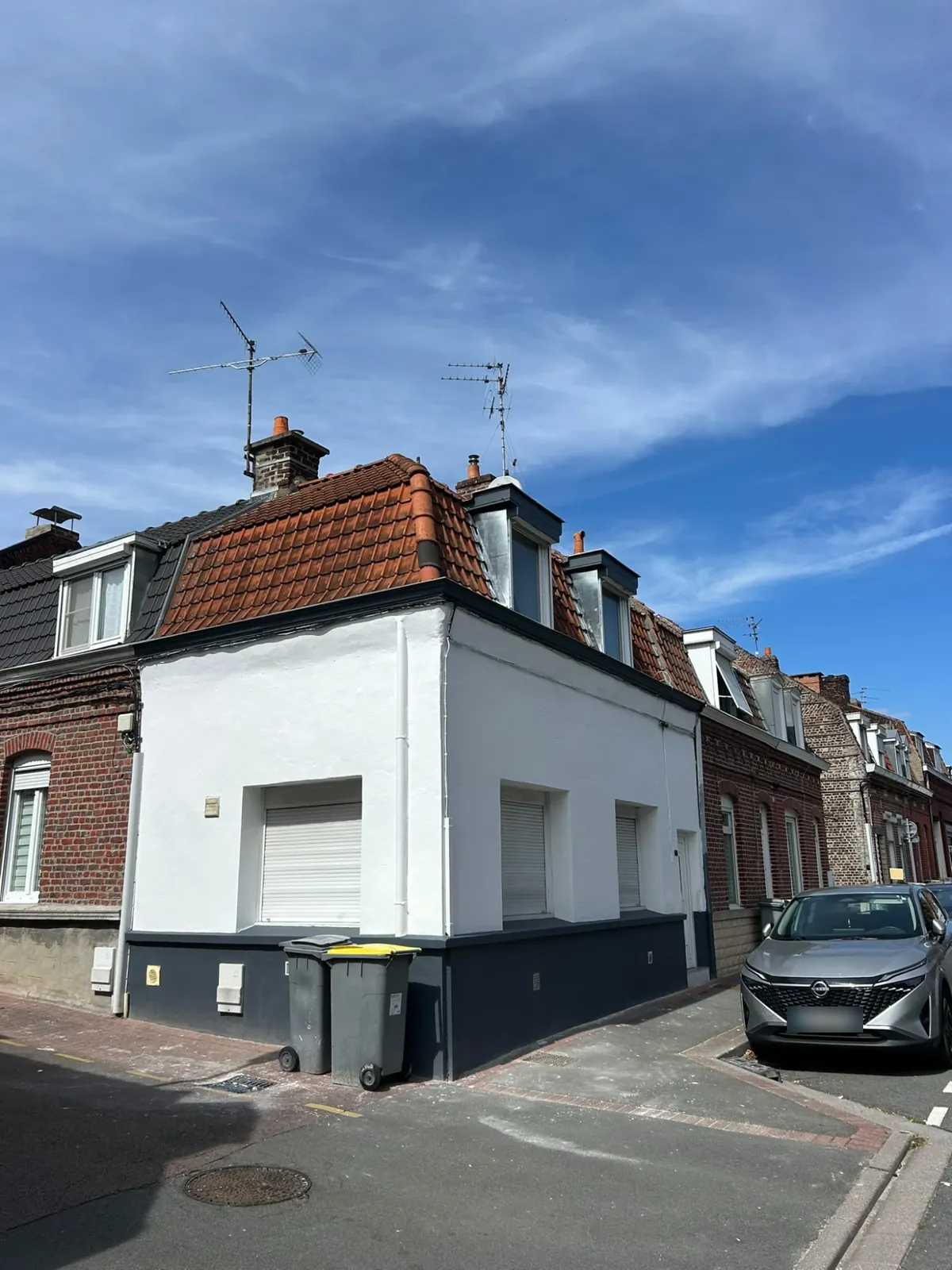 Maison d'angle repeinte, soubassement gris foncé